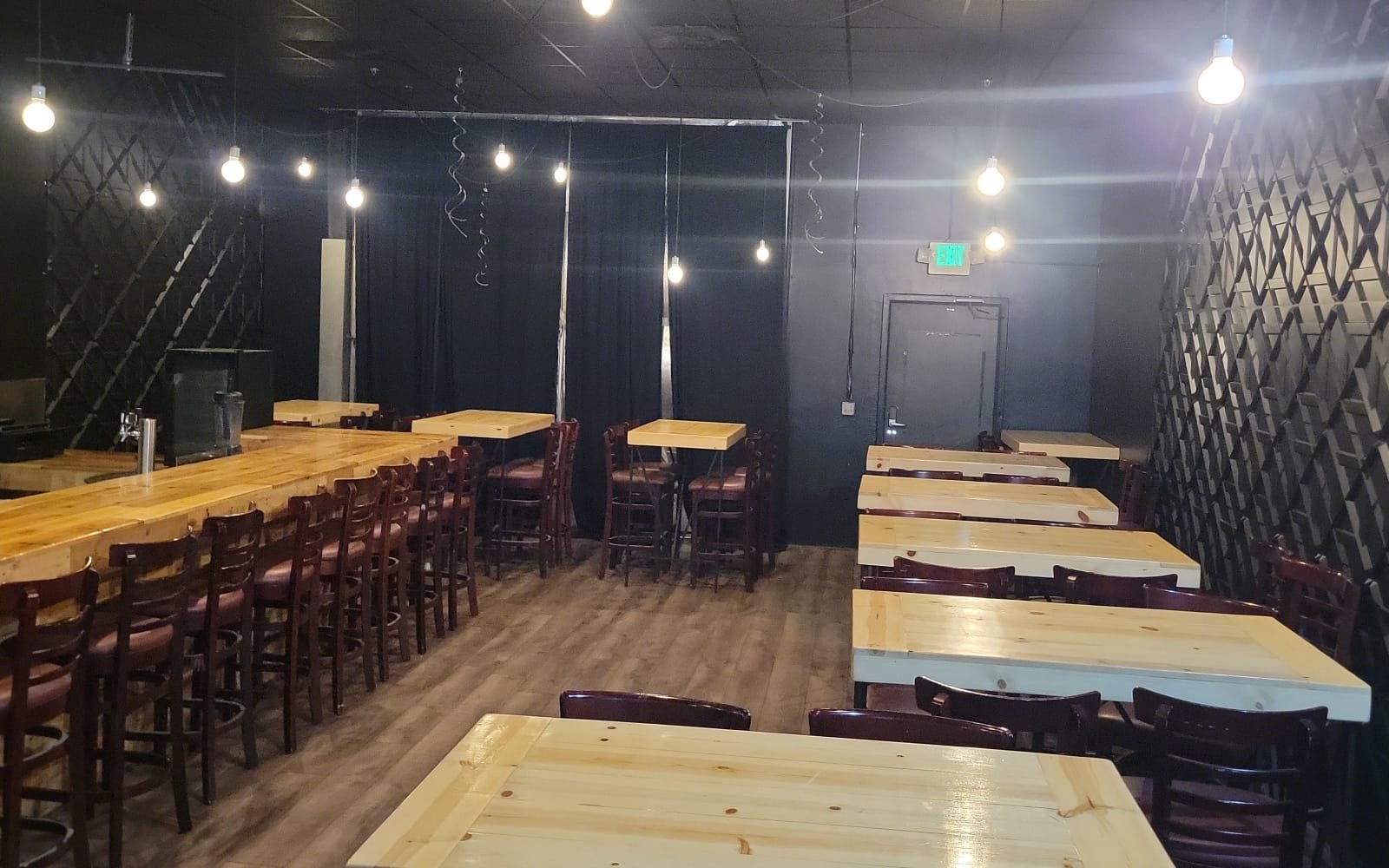 The Bistro: rows of wood tables and a long bar under string lights