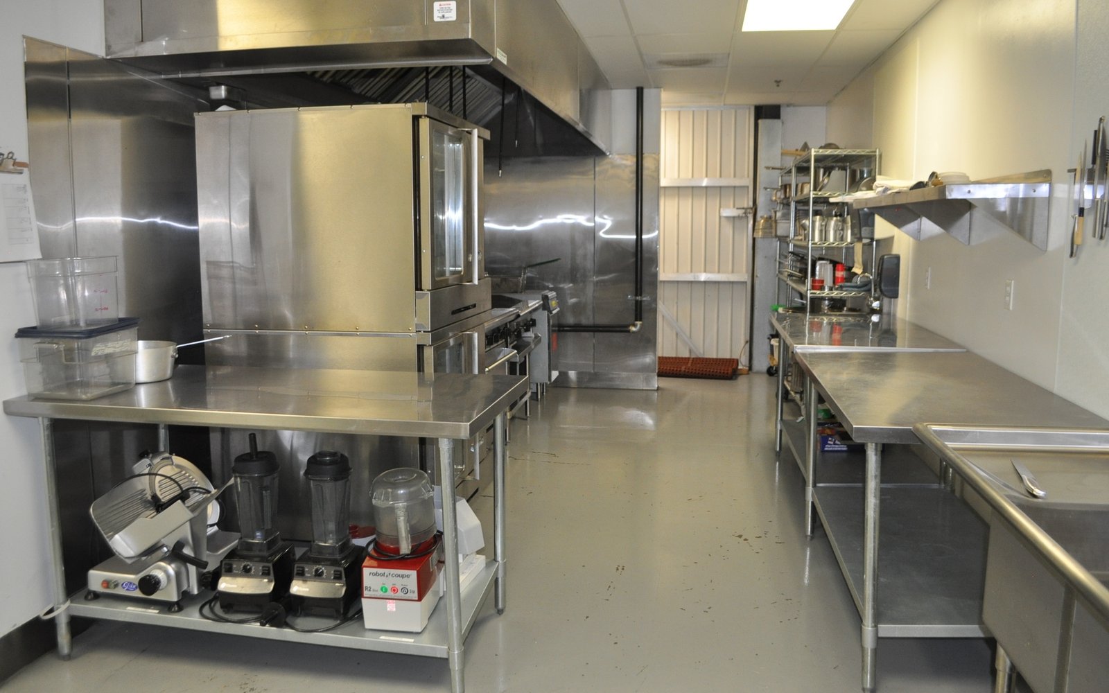 A Cooking Block kitchen: stainless prep tables, convection oven and hood